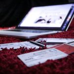 Laptop opened on bed with credit cards surrounding it