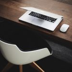 Empty desk chair in front of a laptop indicating someone being out of office