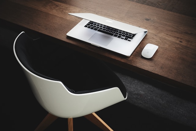 Empty desk chair in front of a laptop indicating someone being out of office