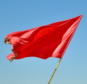 Red flag to symbolize warning signs of fraudulent holiday charity schemes